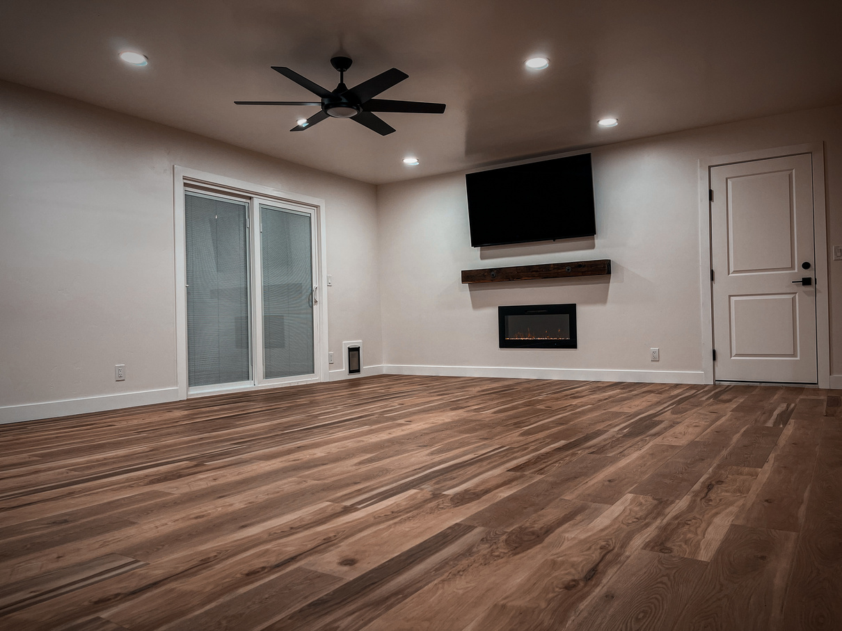 an newly remodeled living room with hardwood floors, a ceiling fan, and built-in electric fireplace